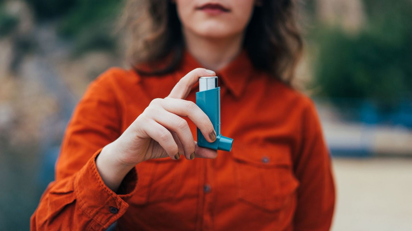 Asthma: woman holding an inhaler in her hand.