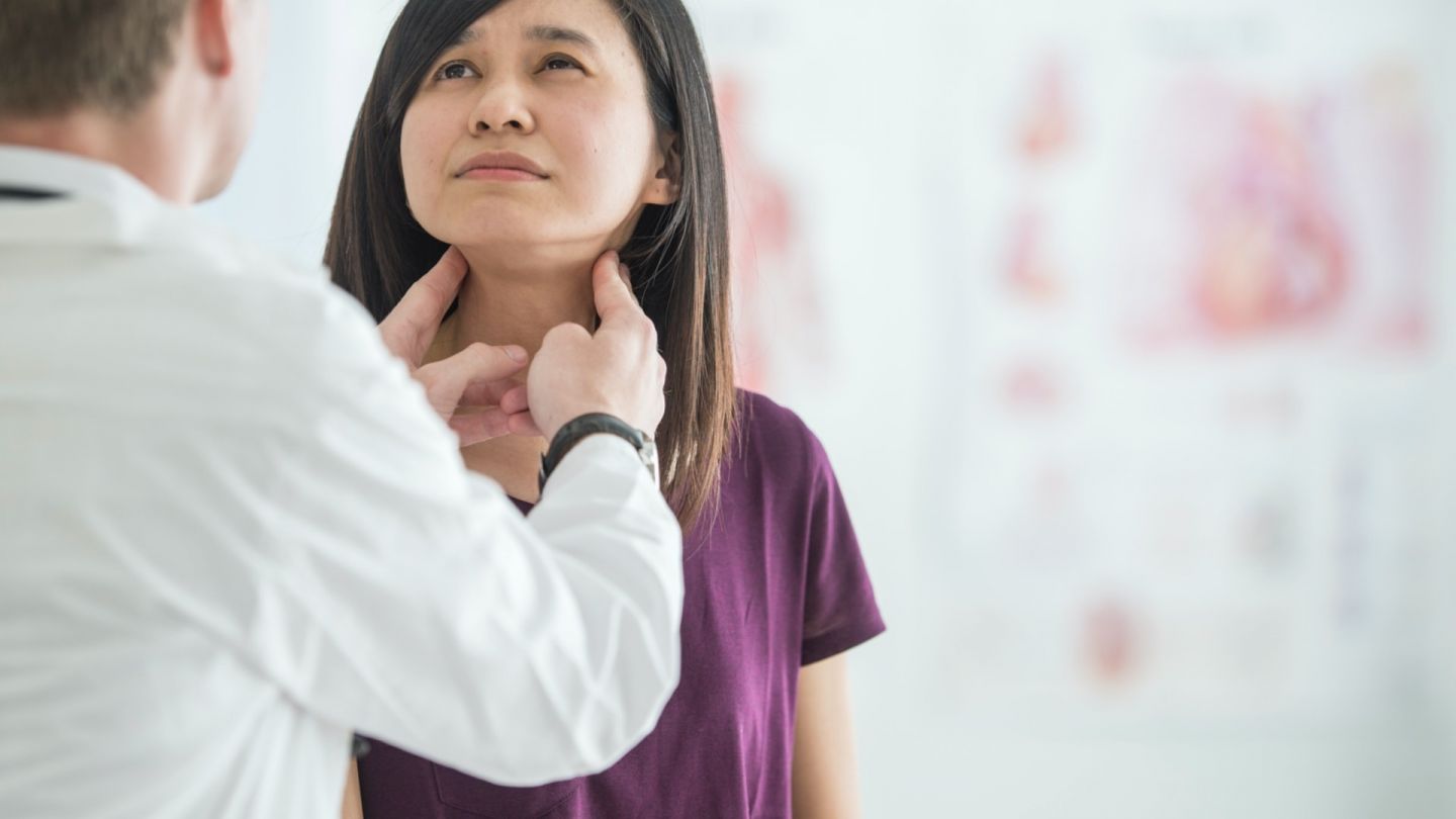 Immune system: doctor palpating a woman’s cervical lymph nodes. The woman is looking up and appears tense.