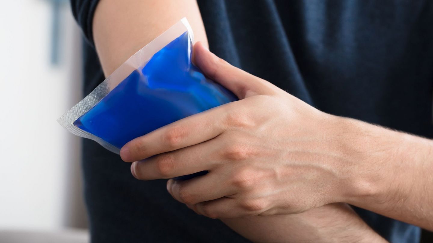 Tennis elbow: man holding an icebag to his elbow.