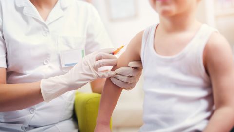 Difteri: Bir çocuk, bir çocuk doktoru tarafından üst kolundan aşılanıyor.