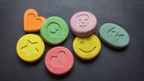 Round pills with symbols including hearts, stars and smiley faces.