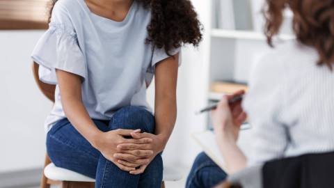 A patient and therapist sit opposite each other during a therapy session.