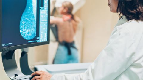 Eine Patientin macht eine Vorsorge-Unterschung. Eine Ärztin überprüft Untersuchungsbilder auf einem Computerbildschirm.