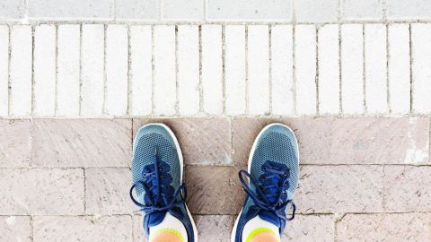 Obsessive-compulsive disorders: feet in sneakers standing on paved path