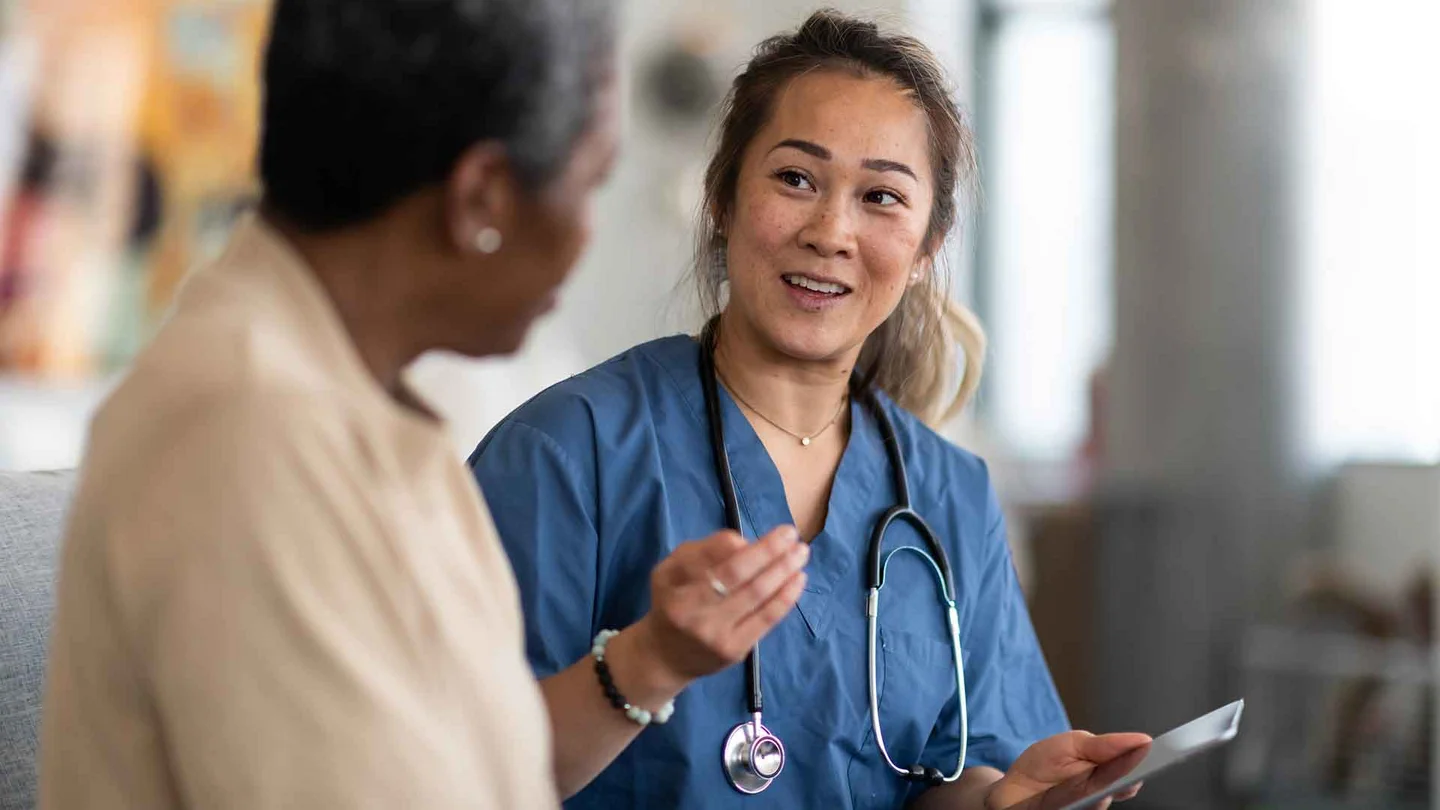 Eine Pflegefachkraft berät eine Patientin.