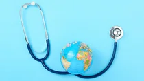 Das Bild zeigt ein Stethoskop und einen Globus.