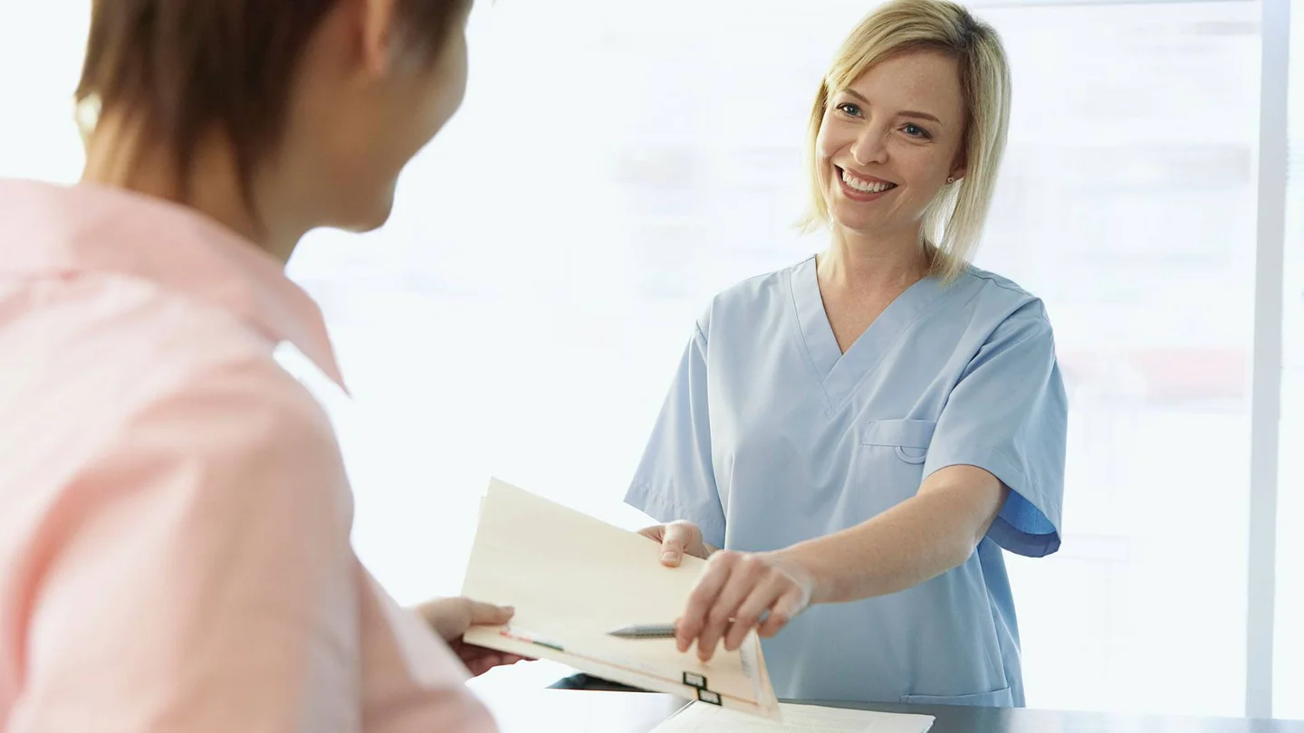 Eine Frau übergibt einer anderen ein Dokument