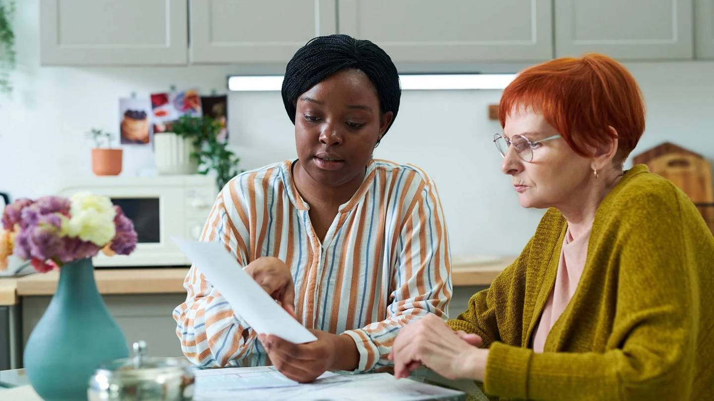 Zwei Frauen schauen gemeinsam auf ein Formular