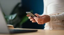 Eine Frau schaut sich auf dem Smartphone ihre E-Verordnung an.