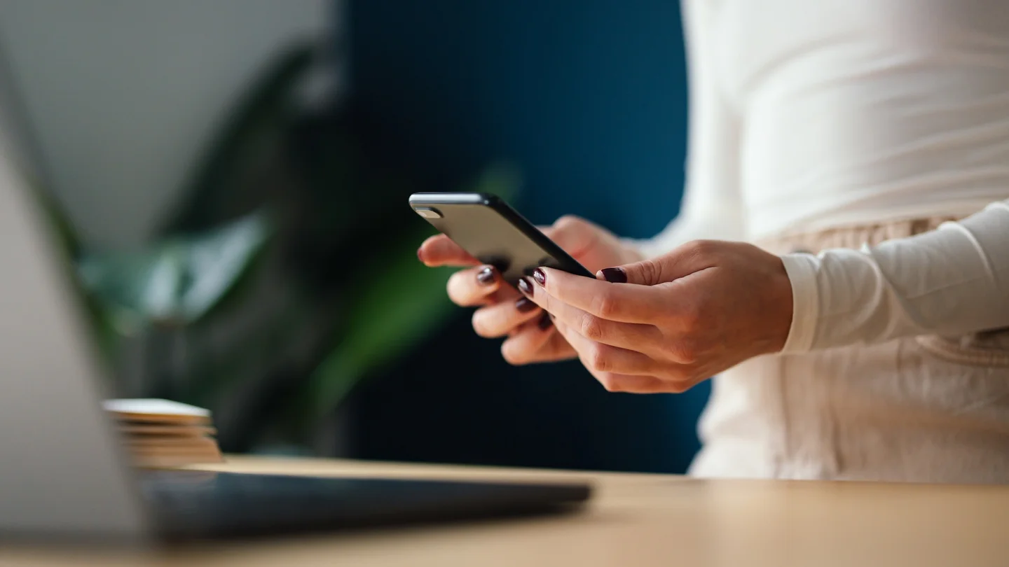 Eine Frau schaut sich auf dem Smartphone ihre E-Verordnung an.